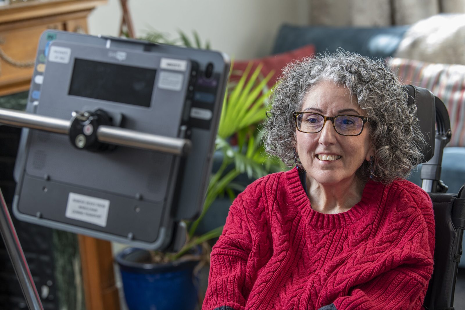 Eine Frau sitzt vor ihrem Sprachcomputer mit Augensteuerung