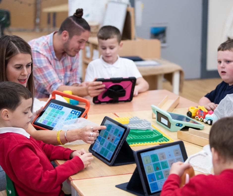 Gruppe uebt gemeinsam mit Tablets an einem Tisch